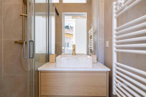 une salle de bain avec un lavabo et un miroir dans l'établissement Appartement neuf 2 pièces Port, à Nice