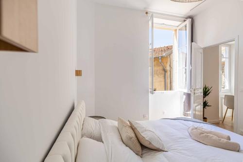une chambre blanche avec un canapé et une fenêtre ouverte dans l'établissement Appartement neuf 2 pièces Port, à Nice
