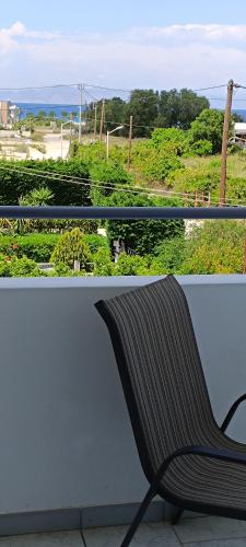 a bench sitting on a balcony looking out at the ocean at Pyrgos Hotel Apartments in Kremasti