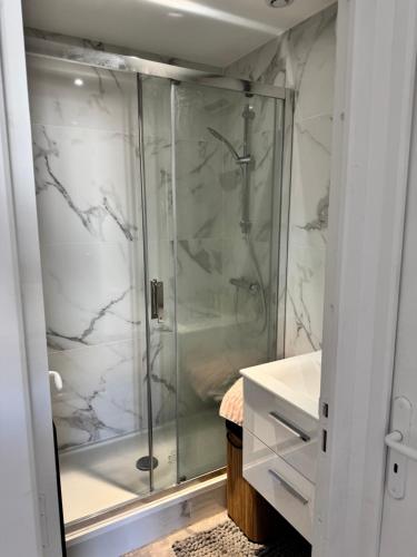 une salle de bain avec une douche avec une porte vitrée dans l'établissement Charmant F3 au Cœur du Havre, au Havre