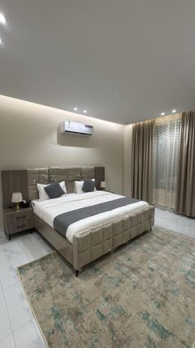 a bedroom with a large bed and a rug at شقق الستين بارك in Khamis Mushayt