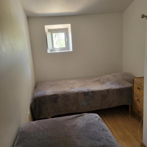 une chambre avec deux lits et une fenêtre dans l'établissement Les Fenals, à Fitou