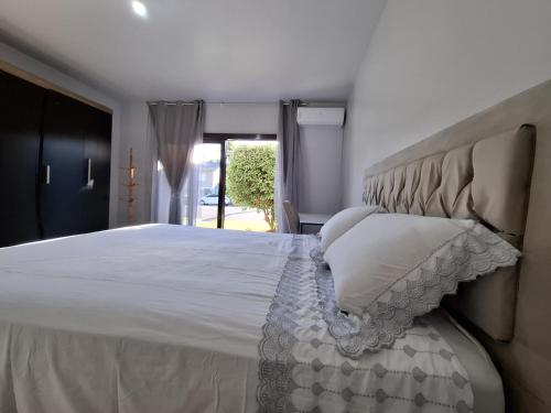 a bedroom with a large white bed and a window at Suíte na cidade do Cristo! in Encantado