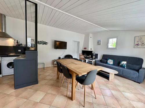 un salon avec une table et un canapé bleu dans l'établissement 507 Les Agapanthes - Pretty one-story house, à Ars-en-Ré