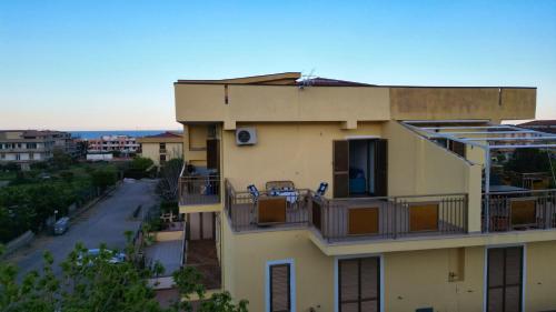 an apartment building with chairs on the balcony at Annì in Torre Melissa