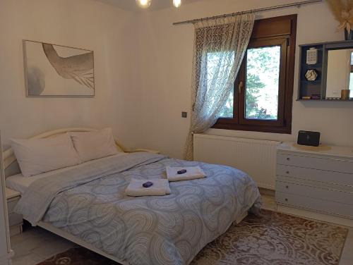 a bedroom with a bed with two towels on it at Oasis Cottage in Krepeni