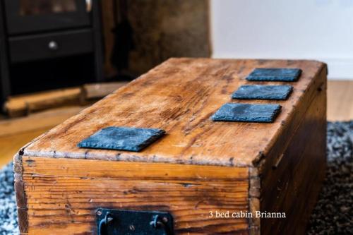 an old wooden chest with four blue tiles on it at Culbokie Lodges in Culbokie