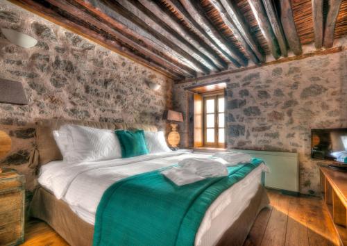 a bedroom with a bed and a window at Cotommatae Hydra 1810 in Hydra