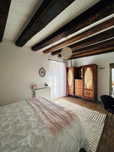 une chambre avec un grand lit et une fenêtre dans l'établissement Appartement de charme du 16ème siècle, à Ménétréol-sous-Sancerre