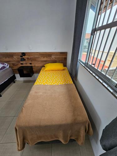 a bed in a room with a large window at Casa no centro de Navegantes in Navegantes