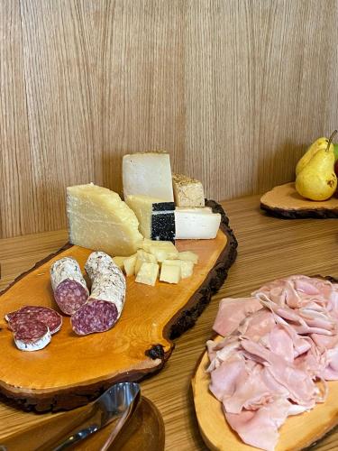 two cutting boards with cheese and meats on a table at Villa Cavalletti Appartamenti in Grottaferrata