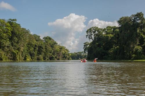 a group of people in a boat on a river at Hotel El Icaco Tortuguero in Tortuguero