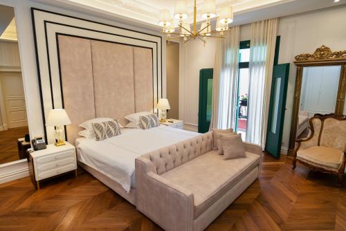 a bedroom with a large bed and a couch at La Fe Boutique Hotel Sarande in Sarandë