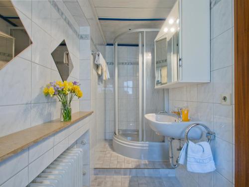 a white bathroom with a sink and a shower at Landpension Am Sommerhang in Bad Rippoldsau