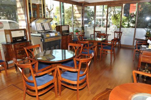 a restaurant with wooden tables and chairs and windows at Hotel Katerina in Athens