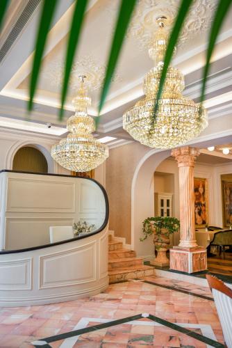 a lobby with chandeliers and a stage at La Fe Boutique Hotel Sarande in Sarandë