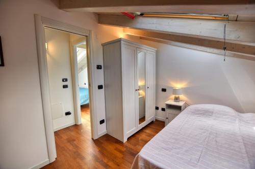 a bedroom with a white bed and a mirror at Bello Pianello Lake View Apartment in Pianello Del Lario