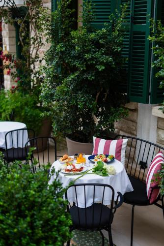 a table with plates of food on top at La Fe Boutique Hotel Sarande in Sarandë