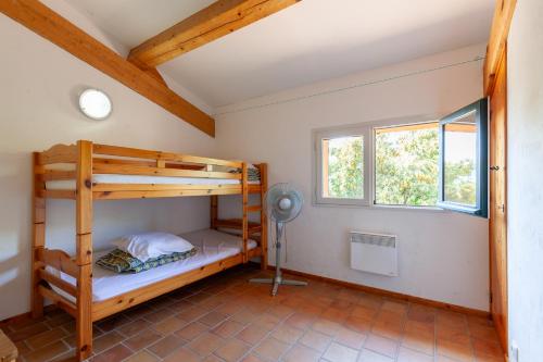 Cette chambre comprend 2 lits superposés et un ventilateur. dans l'établissement Villa Catherine vue mer et terrasse, à Carqueiranne