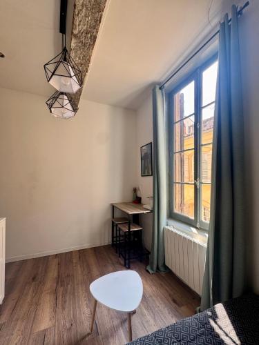 une chambre avec un lit, une table et une fenêtre dans l'établissement Stud'Arles, à Arles