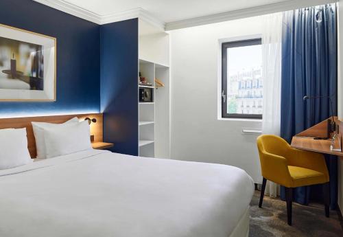 パリにあるB&B HOTEL Paris 17 Batignollesのベッドと机があるホテルの部屋