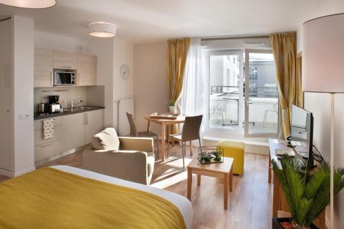 a bedroom with a bed and a kitchen and a living room at DOMITYS - La Plume de Samara - Résidence sénior in Amiens