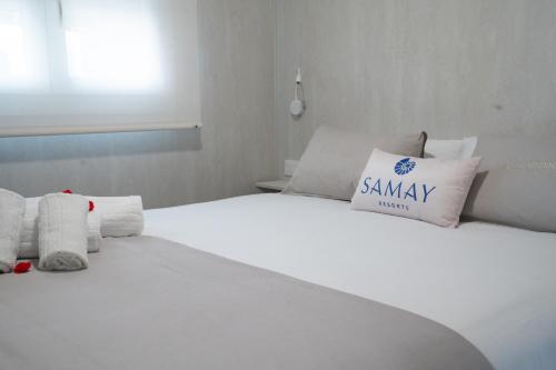 a white bed with a pillow on top of it at La Marina Resort in La Marina