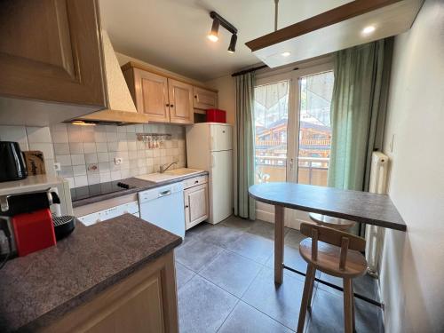 une petite cuisine avec une table et une fenêtre dans l'établissement NOUVEAU Neige et Roc 1 - Appartement 2 chambres centre, à La Clusaz