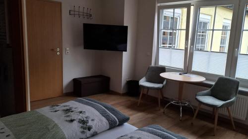 a bedroom with a bed and a table and a tv at Zum Weingutsmuseum in Cochem