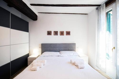 a bedroom with a large white bed with two towels at Tesoro Dé Galluzzi in Bologna