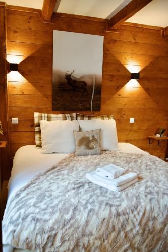 - une chambre avec un grand lit et des murs en bois dans l'établissement Hotel Restaurant Le Col de Crous, à Péone