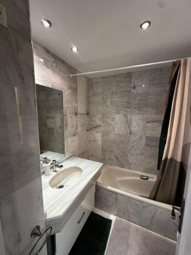 a bathroom with a tub and a sink and a bath tub at Green Hill Apartment in La Cala de Mijas