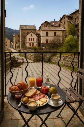 een dienblad met ontbijtproducten op een tafel op een balkon bij Hotel Restaurant Le Col de Crous in Péone