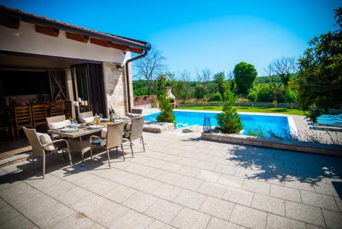 a patio with a table and chairs next to a pool at Villa Tia in Mostar