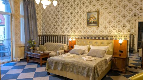 Un dormitorio con una cama, un sofá y una mesa. en Hotel Pension Bella, en Berlín