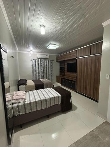 a bedroom with two beds and a flat screen tv at Casa da piscina in Macapá
