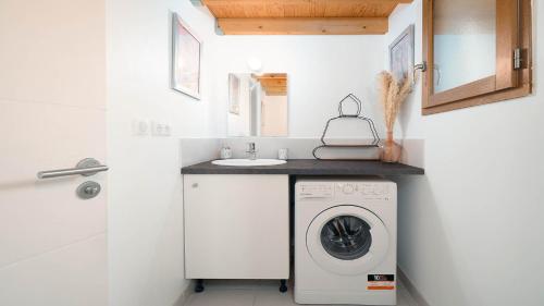 une salle de bain avec une machine à laver et un lavabo dans l'établissement El Rancho - ST4 Mezzanine, au Grau-du-Roi