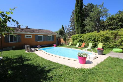 une piscine dans une cour avec des chaises et une maison dans l'établissement PROVENCE VAUCLUSE VELLERON Superbe maison avec piscine tout confort, à Velleron