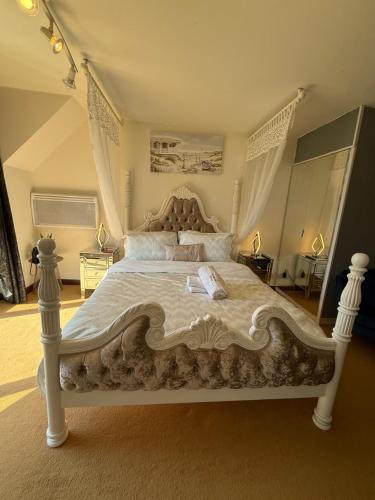 a bedroom with a large white bed with a canopy at Barnfields Retreat in Little Clacton