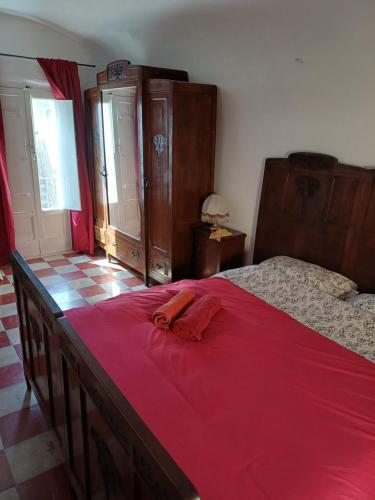 a bedroom with a bed with a red blanket on it at Casa Santa Chiara in Triggiano