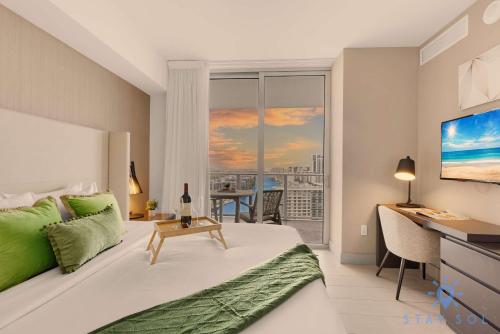 Un dormitorio con una cama y un escritorio y una ventana. en High-Floor with Stunning Views-Luxury Condo - Pools, en Hollywood