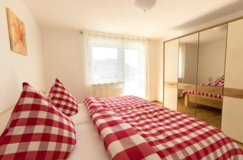 a bedroom with a red and white checkered bed at Ferienwohnung Baßler in Kappelrodeck