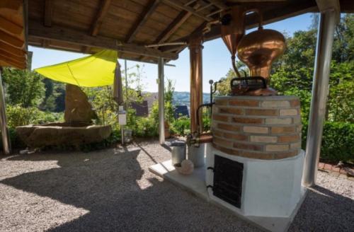 a patio with a fireplace and an umbrella at Ferienwohnung Baßler in Kappelrodeck