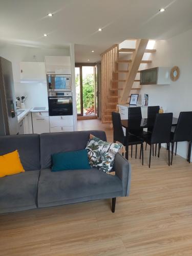 a living room with a couch and a dining room and kitchen at Le Duplex du Plongeoir - spacieux T3 de 65m2 avec vue sur le lac de Serre Ponçon in Savines