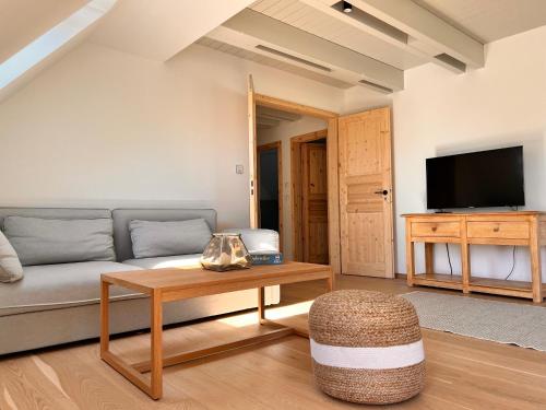 una sala de estar con un sofá y una mesa en Sommerby Sky, en Brodersby