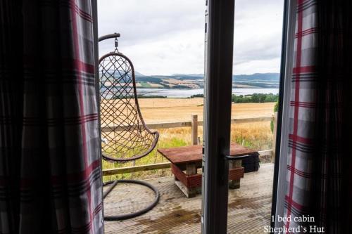 a view from a window with a swing at Culbokie Lodges in Culbokie