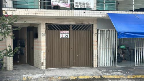 a building with a brown door with a sign on it at Residencial Sol Nascente in Porto Seguro