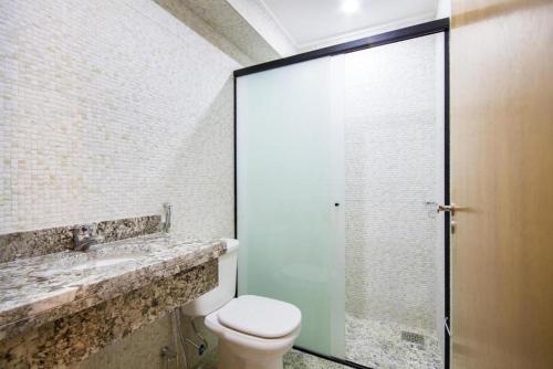 a bathroom with a toilet and a glass shower at Cassino All Inclusive Resort Poços de Caldas By Nacional Inn in Poços de Caldas