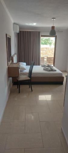 a bedroom with a bed and a chair and a window at Petrino 2 semibased by Vasileia in Sarti