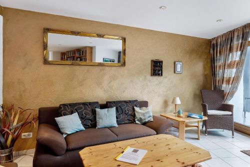 a living room with a brown couch and a mirror at Ferienwohnung Würtenberger 68 qm in Öhningen